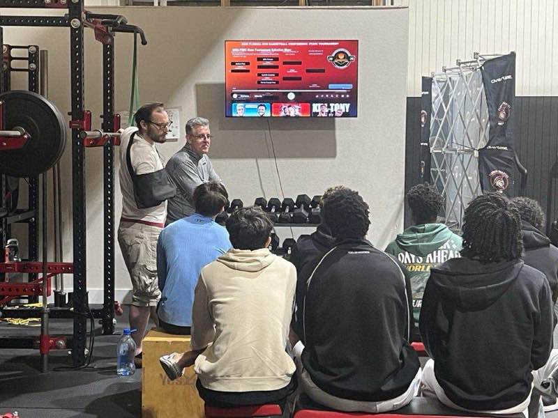 FCP Sports basketball film study session — youth players watching chalk talk in Fort Walton Beach